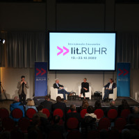 lit.RUHR 2022: 21.10.: Gebärdensprachdolmetscher (transignum), Andreas Löschel, Mona Neubaur & Michael Hirz ©Ast/Juergens